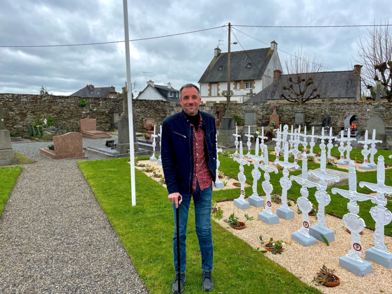 Frédéric André pose devant le carré militaire du cimetière de Lannion.